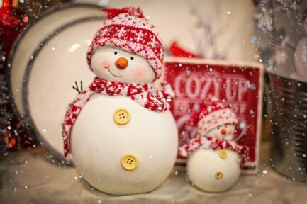Two handmade ceramic snowmen, one large and one small, wearing snow caps and scarves with button details, used decoratively on the Perry Hall Craft Fair homepage.